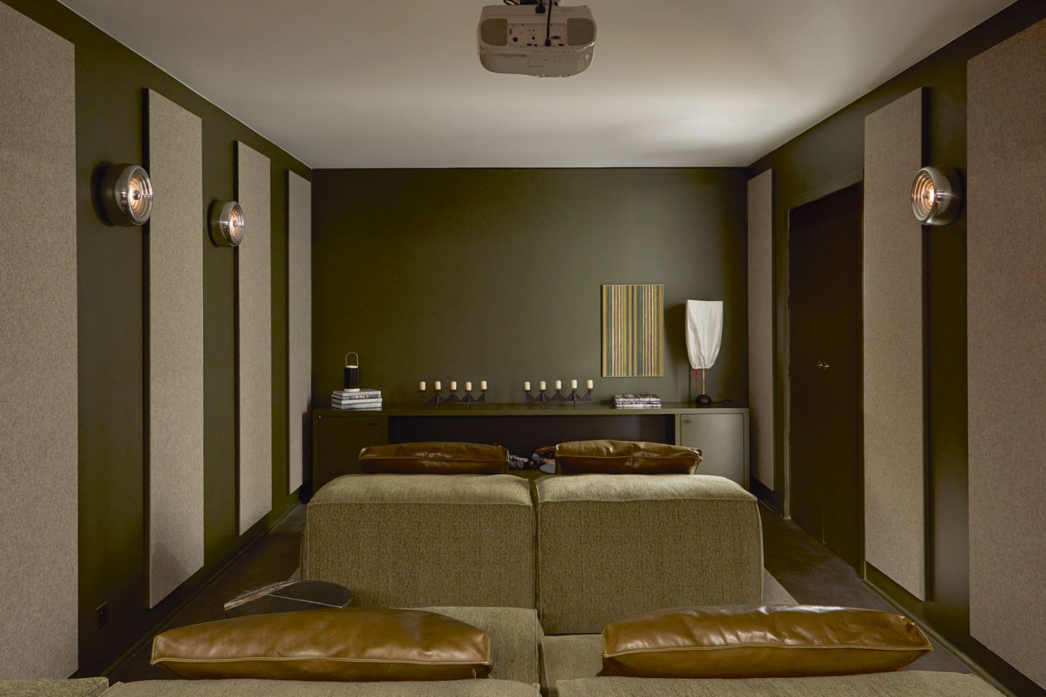 Dark-hued walls create a cocooning atmosphere in the media room, paired with the Living Divani Extrasoft sofa by Piero Lissoni, vintage Flos Padina wall lights by Achille Castiglioni and an antique lamp by Isamu Noguchi on the console