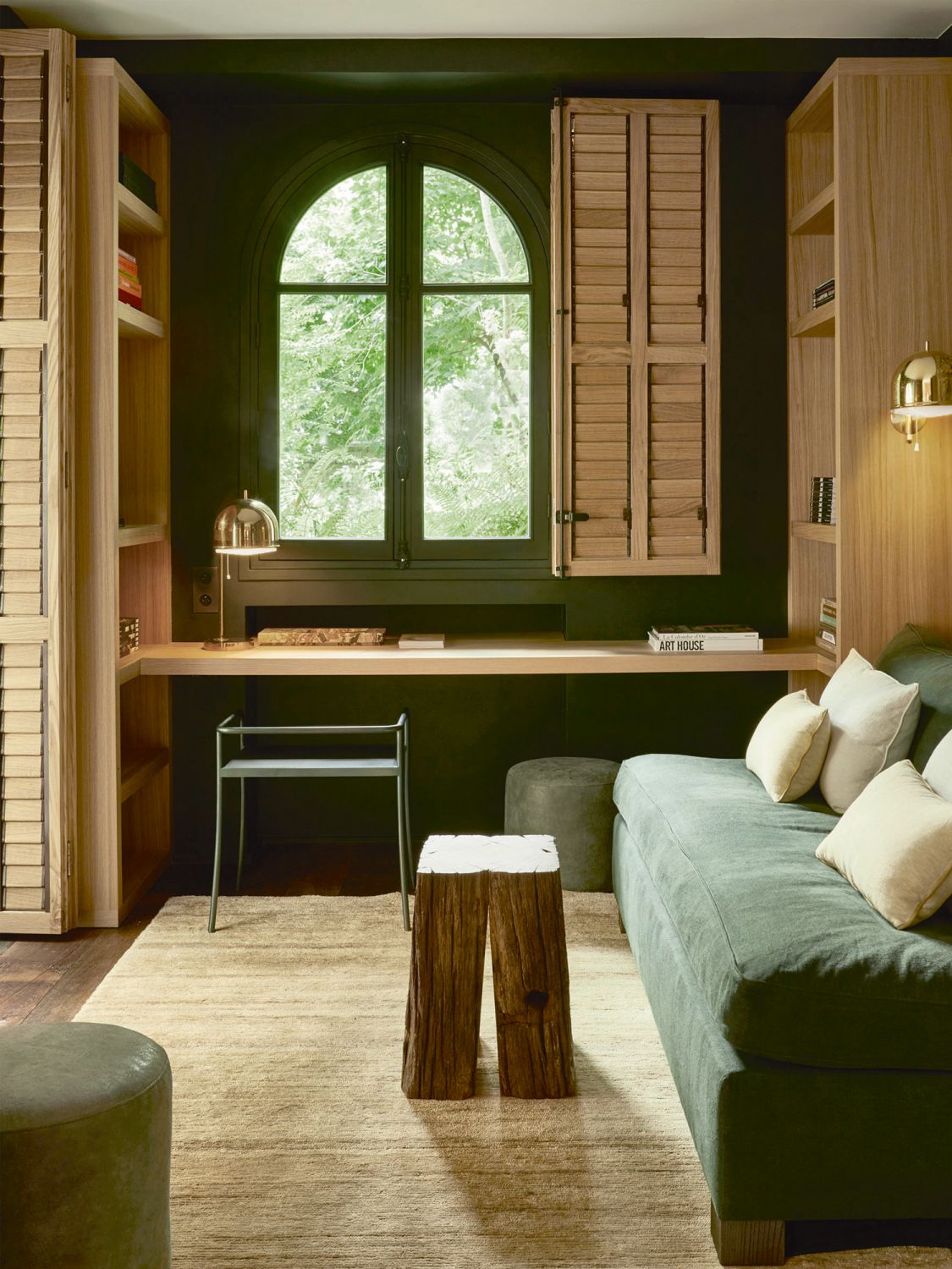 The cosy library is furnished with a custom sofa upholstered in a Pierre Frey velvet fabric, stools from Atelier Musset, a DUL chair by Christophe Delcourt and a Nanimarquina Noche rug
