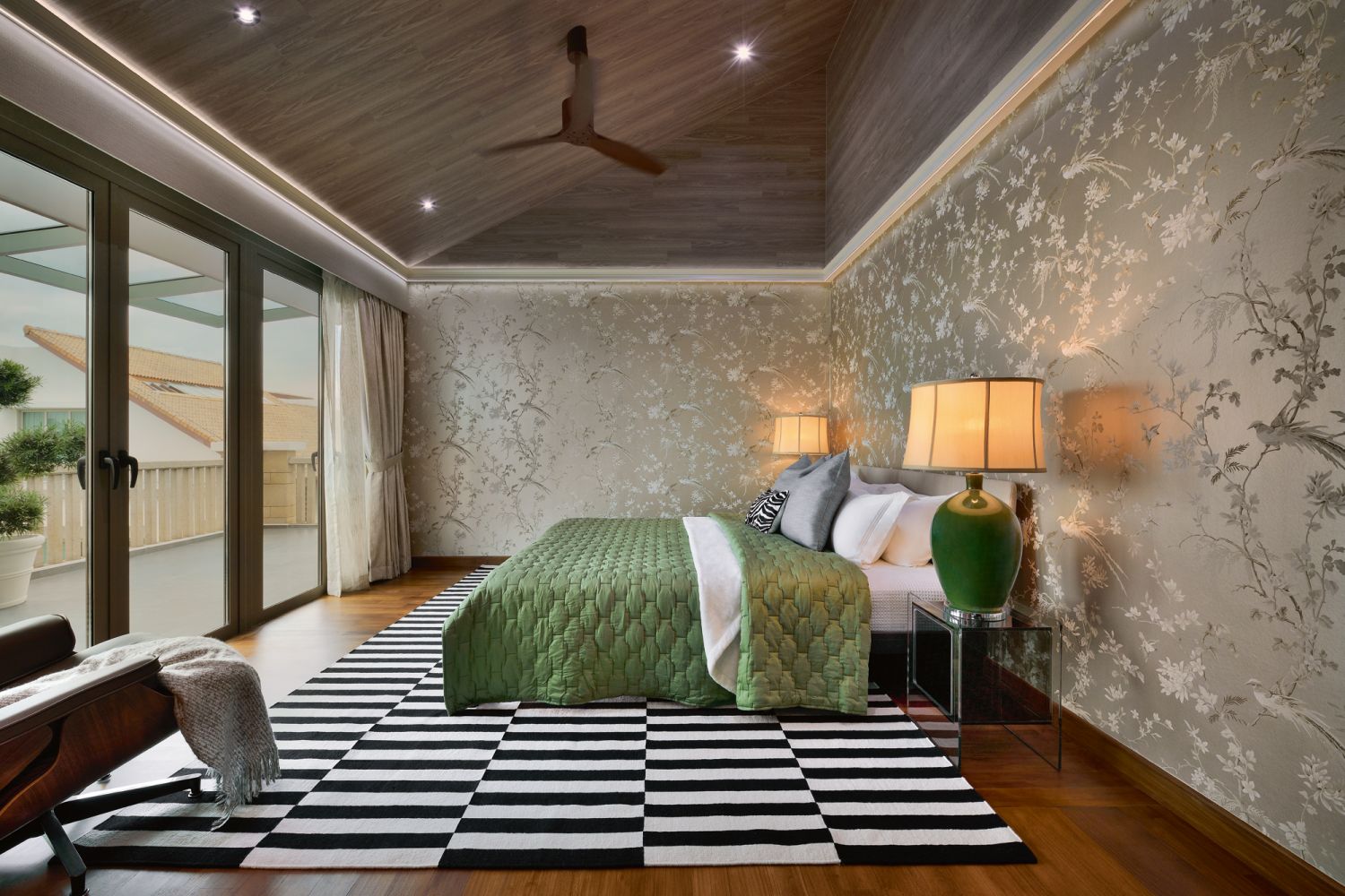 Green lamps and custom chinoiserie-style gold wallpaper give the master suite an Asian touch