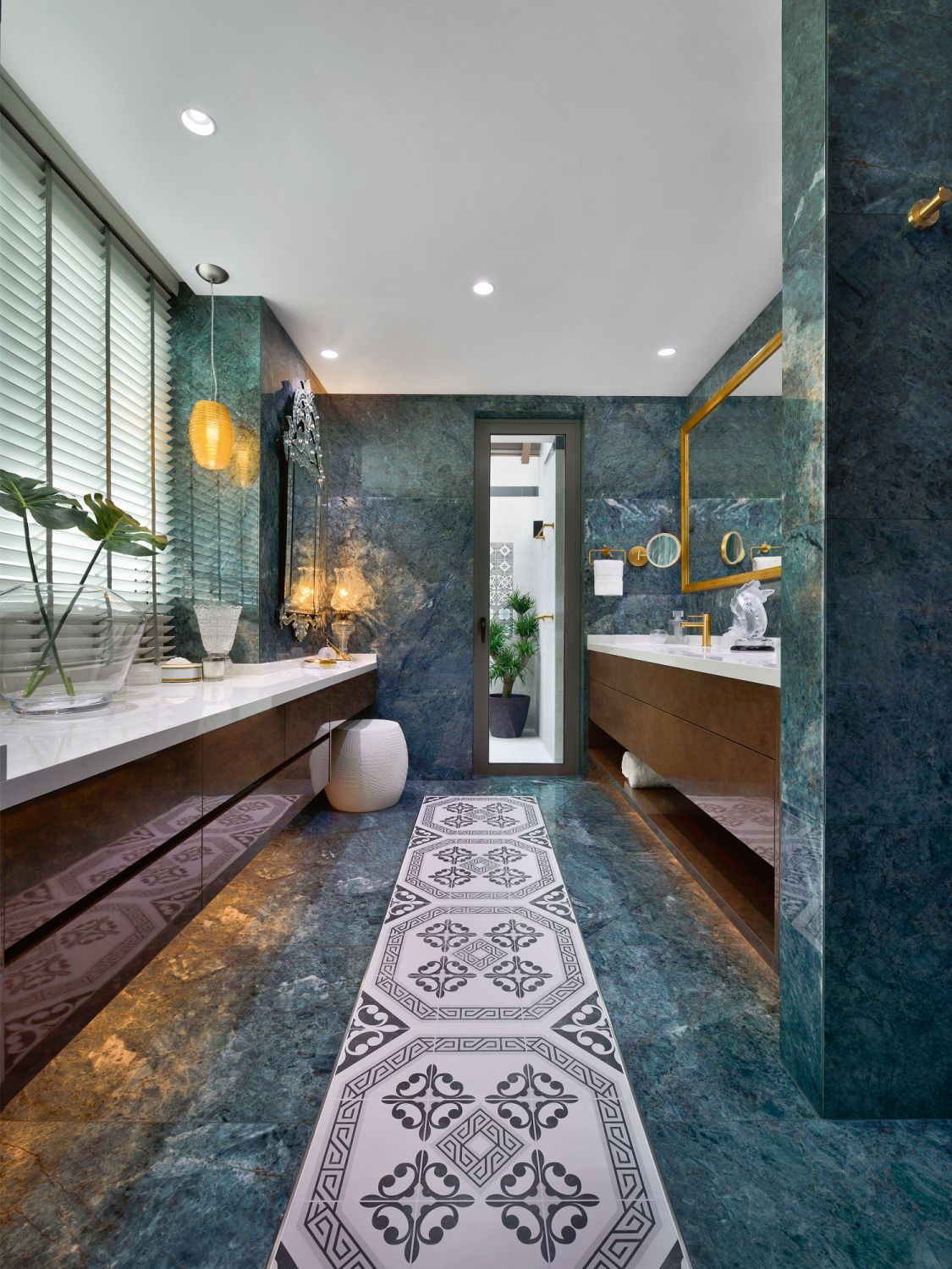 The generous application of green marble tiles, paired with gold detailing on the faucets, mirror and Vistosi lights creates a luxurious look in the master bathroom