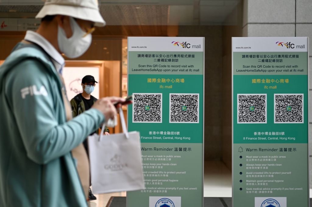 HONG KONG, CHINA - FEBRUARY 24: A pedestrian walks by QR codes for the LeaveHomeSafe Covid-19 contact-tracing app in front of a shopping mall on February 24, 2022 in Hong Kong, China. (Photo by Li Zhihua/China News Service via Getty Images)