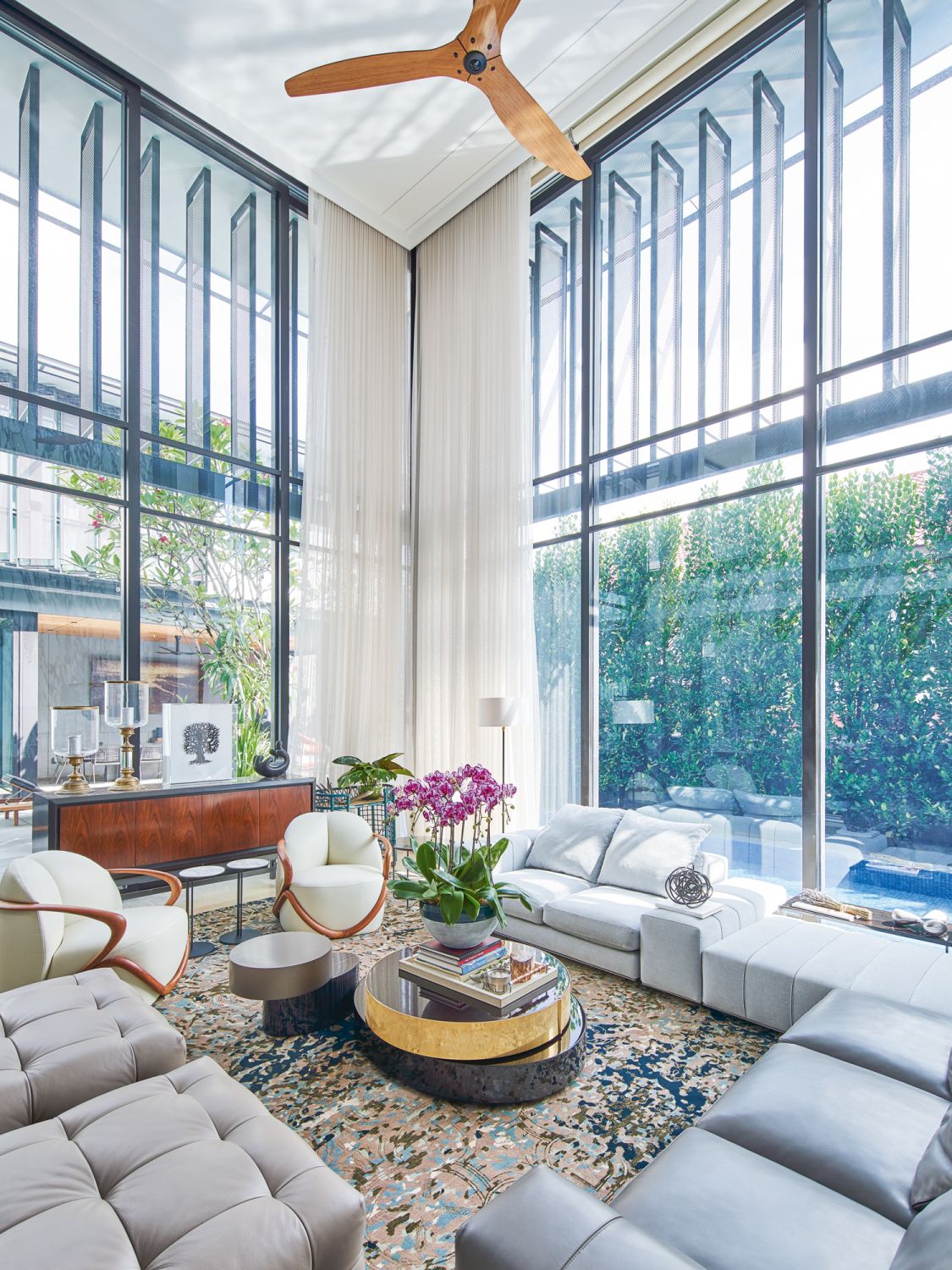 This double-volume living room is furnished with a pair of Giorgetti Hug chairs and the Minotti Freeman sofa by Rodolfo Dordoni