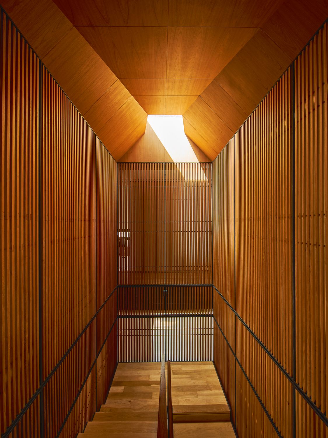 The skylight and faceted ceiling augment the dramatic impact of the teak-clad staircase