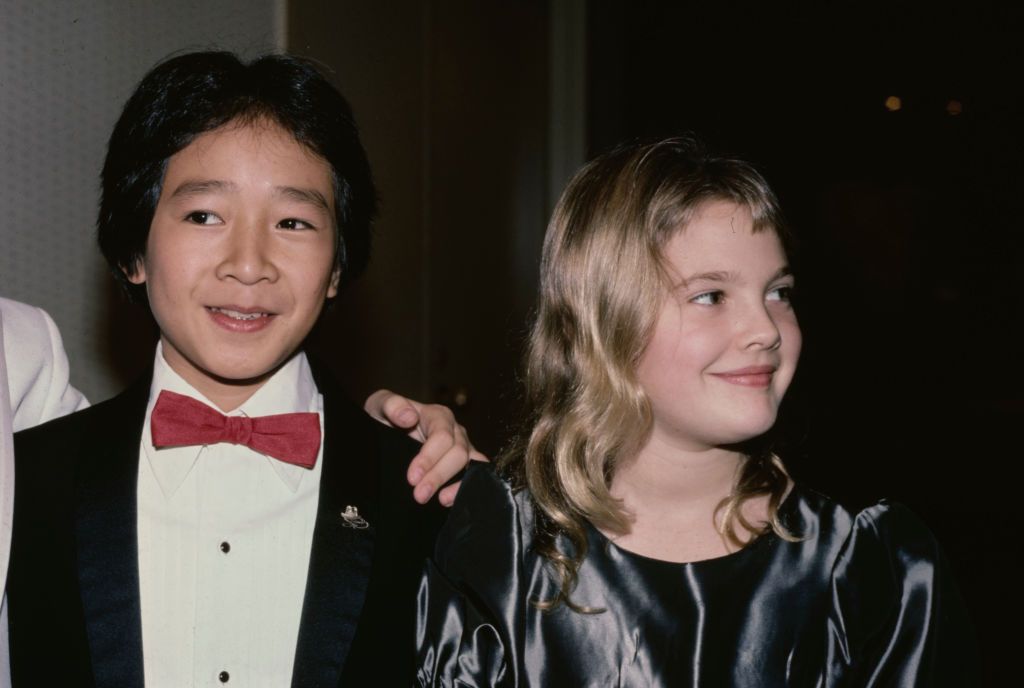 American actor Ke Huy Quan, wearing a tuxedo with a red bow tie, and American actress Drew Barrymore, wearing a grey silk outfit with a round neckline, attend the 6th Youth in Film Awards, in Los Angeles, California, 2nd December 1984. Barrymore is nominated for the Best Young Actress in a Motion Picture (Musical, Comedy, Adventure or Drama) award for her performance in 'Irreconcilable Differences', and Quan is nominated for the Best Young Supporting Actor in a Motion Picture (Musical, Comedy, Adventure or