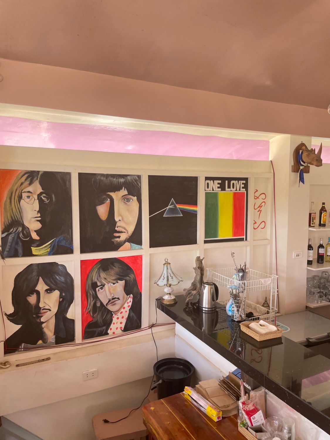 Paintings of The Beatles, Pink Floyd's The Dark Side of the Moon, and Bob Marley's "One Love" slogan