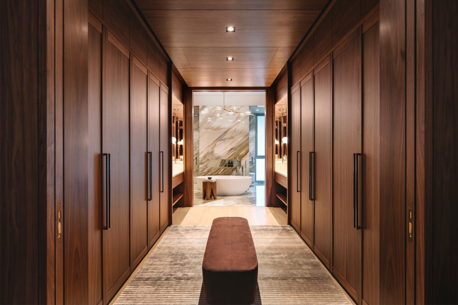 A luxurious bathroom designed by Brewin Design Office is part of a walk-in wardrobe