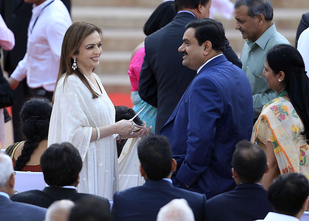 NEW DELHI, INDIA - MAY 26: Nita Ambani greets Adani Group head Gautam Adani during a swearing-in ceremony for new Indian Prime Minister Narendra Modi and his cabinet ministers at Rashtrapati Bhavan on May 26, 2014 in New Delhi, India. 63-year-old Modi was sworn in as Prime Minister alongwith other 44 ministers before the largest-ever gathering at Rashtrapati Bhawan, which became a confluence of people as varied as Presidents, Prime Ministers, film stars, corporate and religious leaders. (Photo by Ajay Aggar
