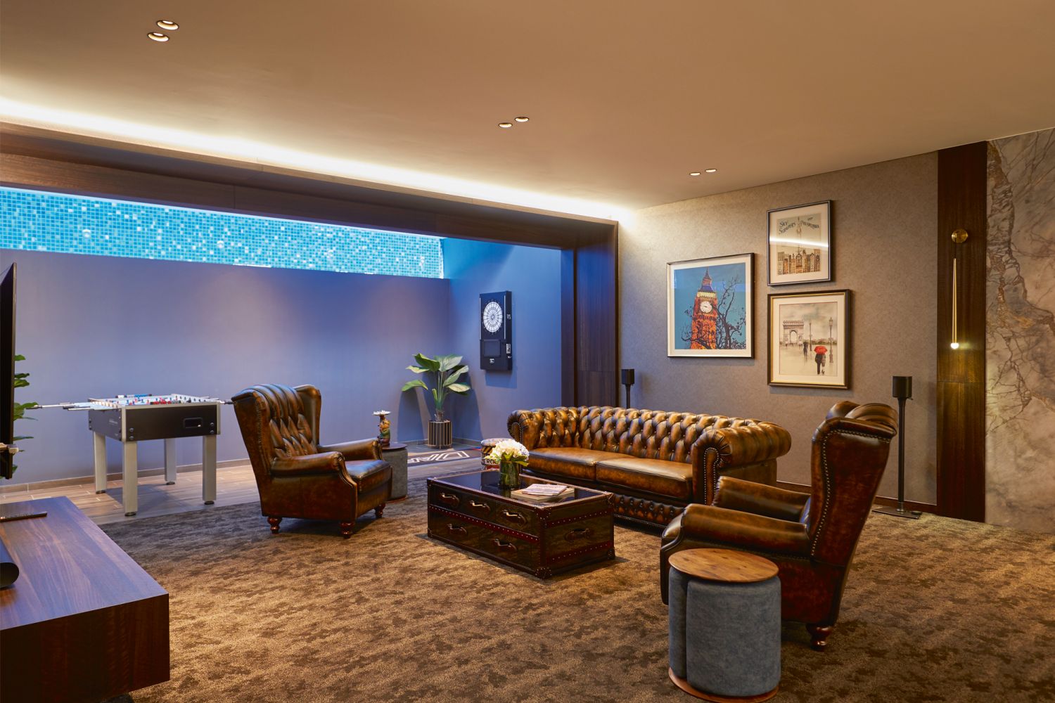 This basement lounge is a fully carpeted space designed in the style of a gentlemen’s club