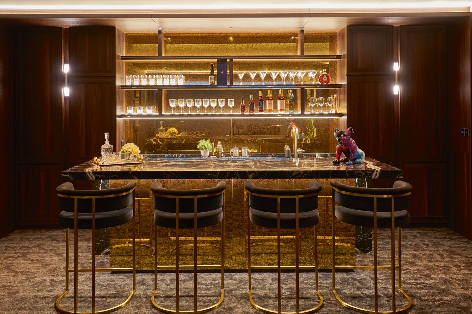 The counter’s burnished gold mirrored finish and Black Roso marble top add to the opulent appeal of the bar area