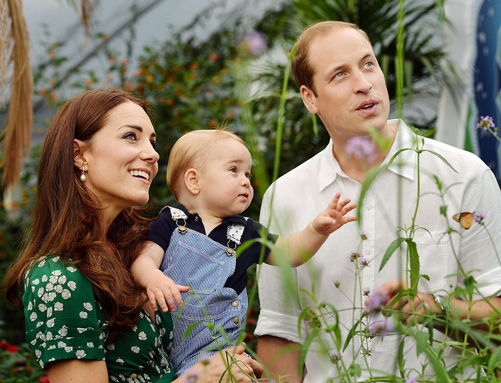LONDON, ENGLAND - JULY 02: (EDITORIAL USE ONLY) Catherine, Duchess of Cambridge holds Prince George as he and Prince William, Duke of Cambridge's look on while visiting the Sensational Butterflies exhibition at the Natural History Museum on July 2, 2014 in London, England. The family released the photo ahead of the first birthday of Prince George on July 22. (Photo by John Stillwell - WPA Pool/Getty Images)