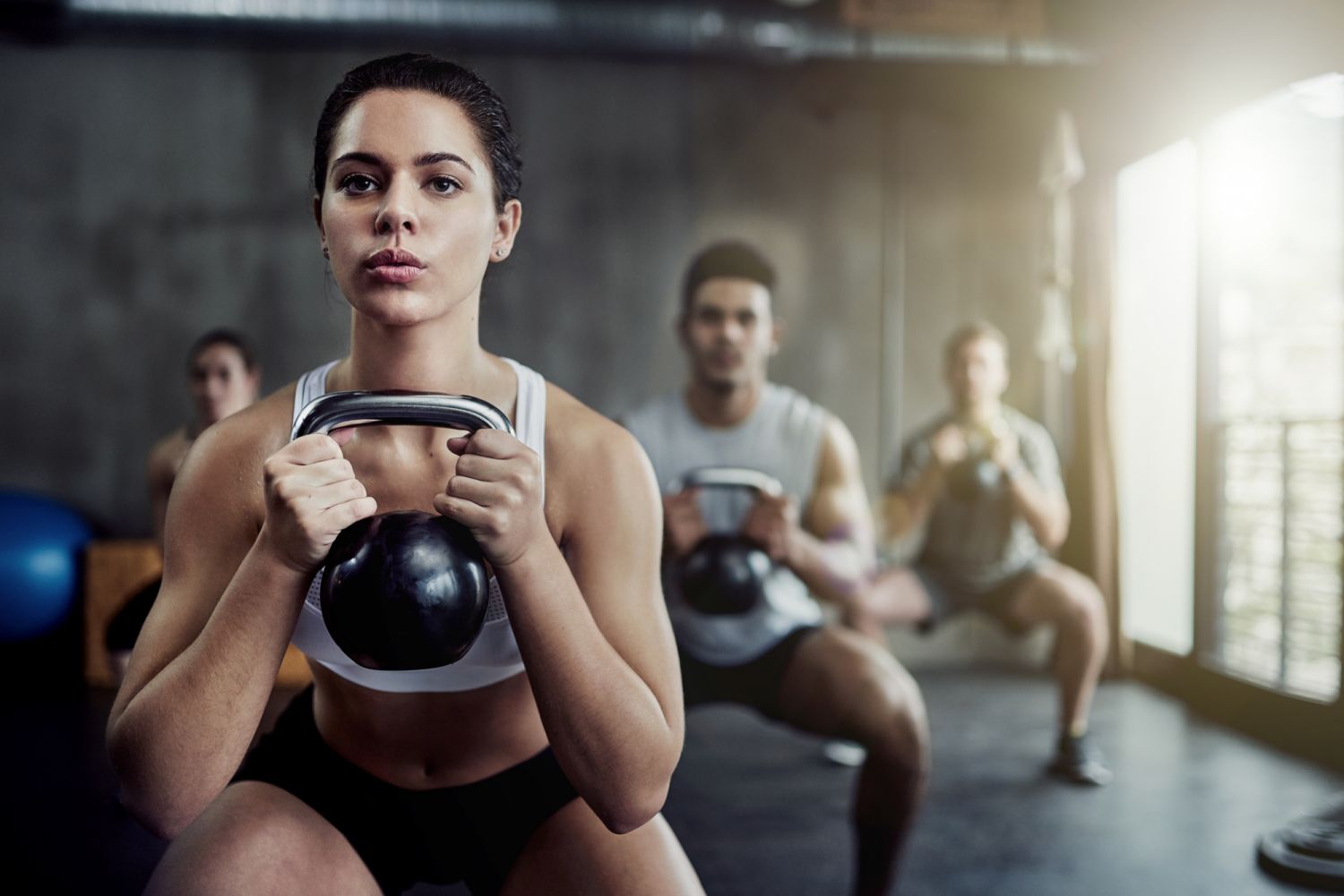 Shot of a fit young woman working out with a kettle bell at the gym