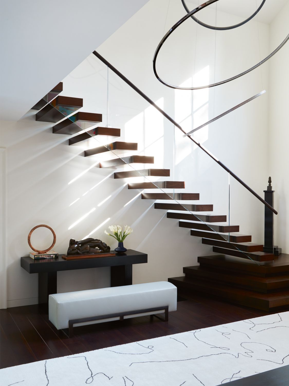 Supported by a glass balustrade, the floating steps add intrigue to the home