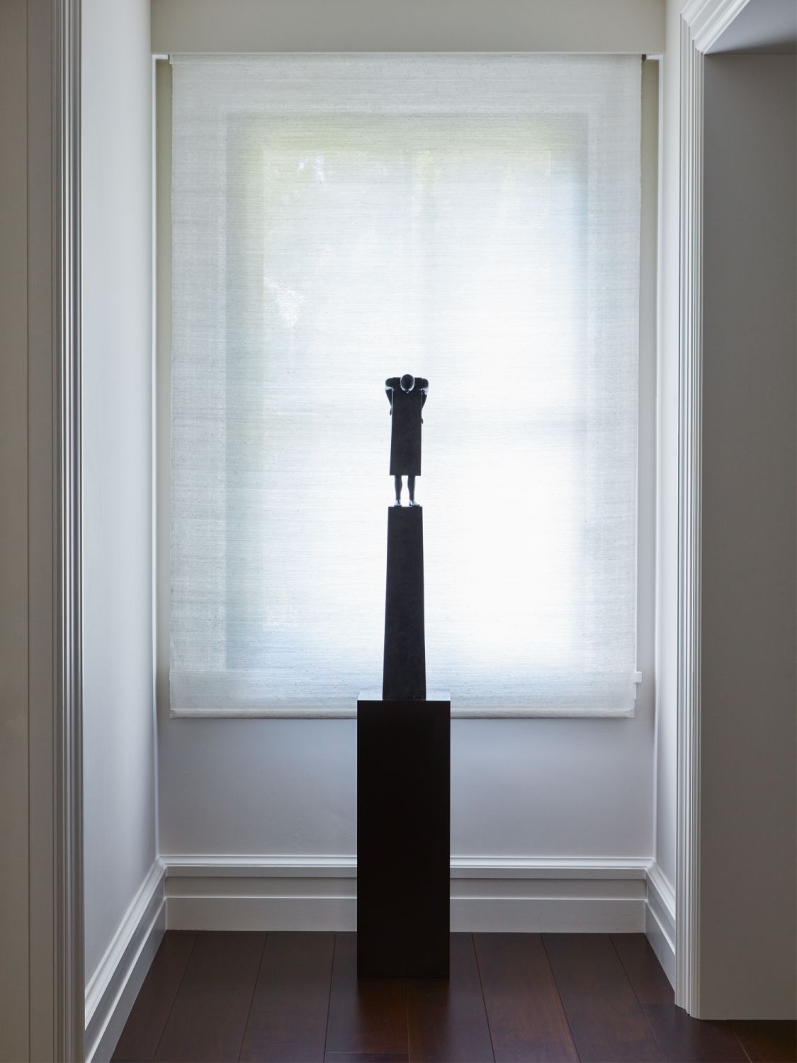 A sculpture at the end of a hallway adds intrigue to this space