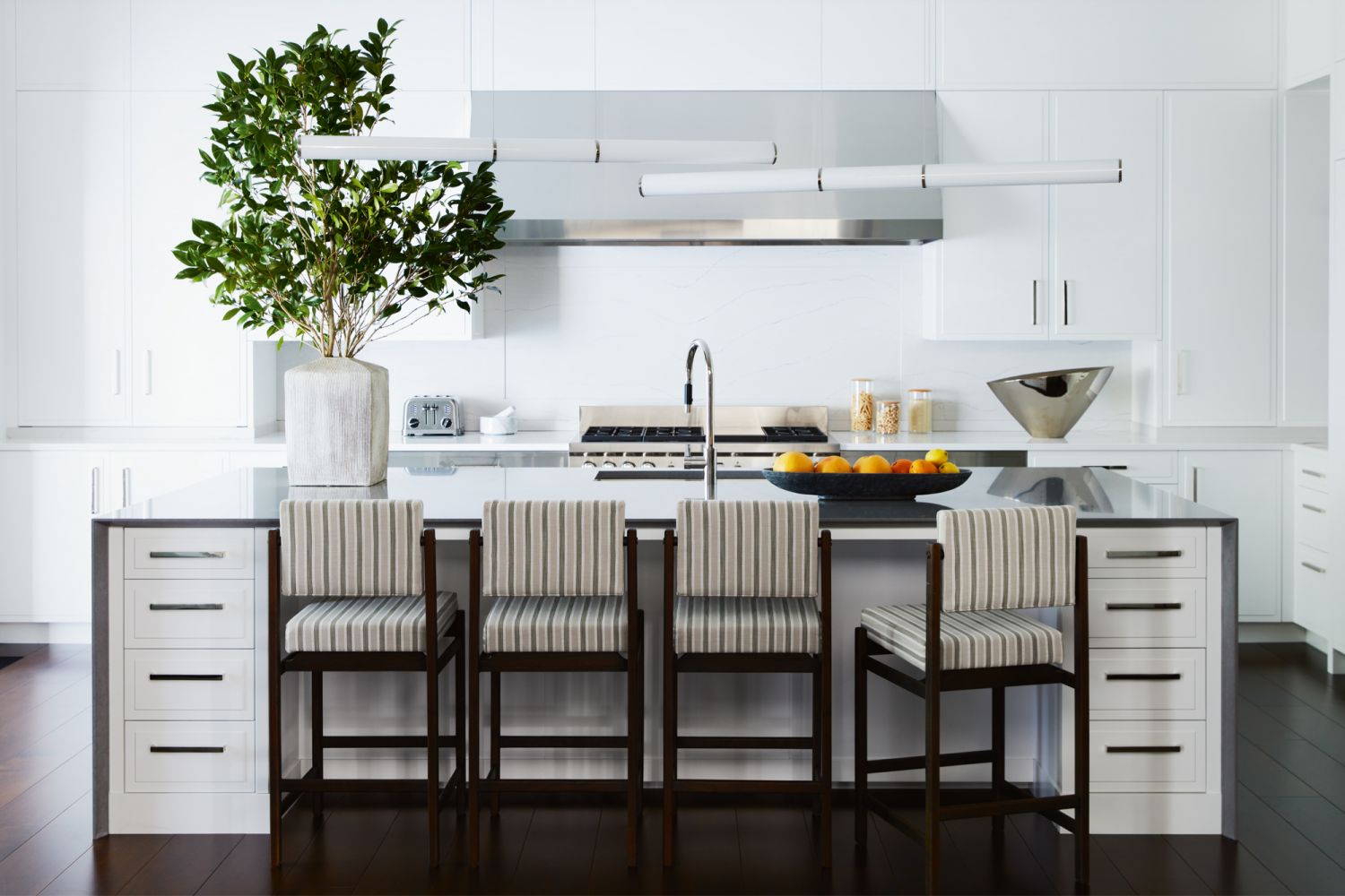 The dry kitchen features lighting pieces from Roll & Hill and bar stools from Thomas Hayes Studio