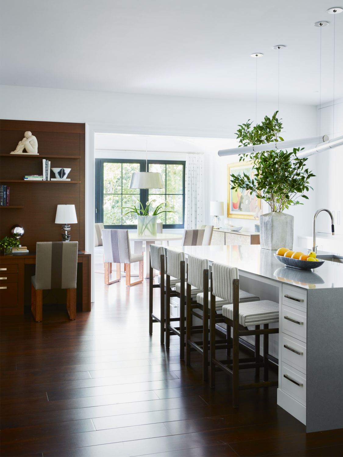 The calming kitchen area includes a small study nook with display shelves that showcase books and objets d’art