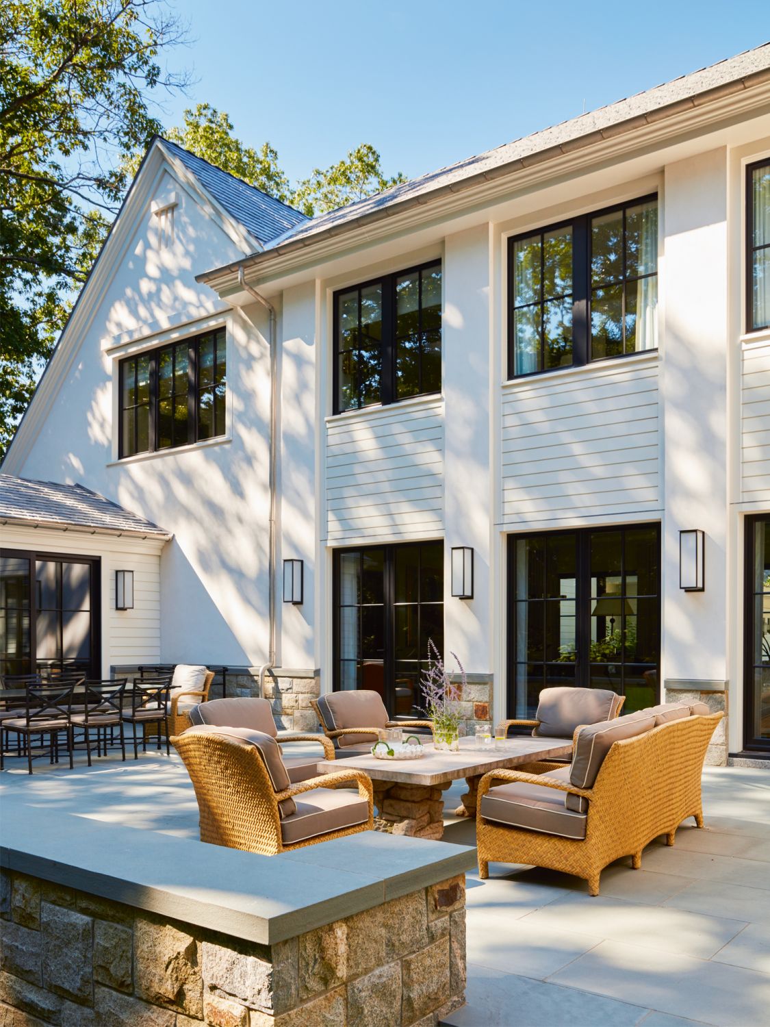 The backyard features rattan outdoor furnishings that encourage the couple to dine al fresco with their guests on fair weather day