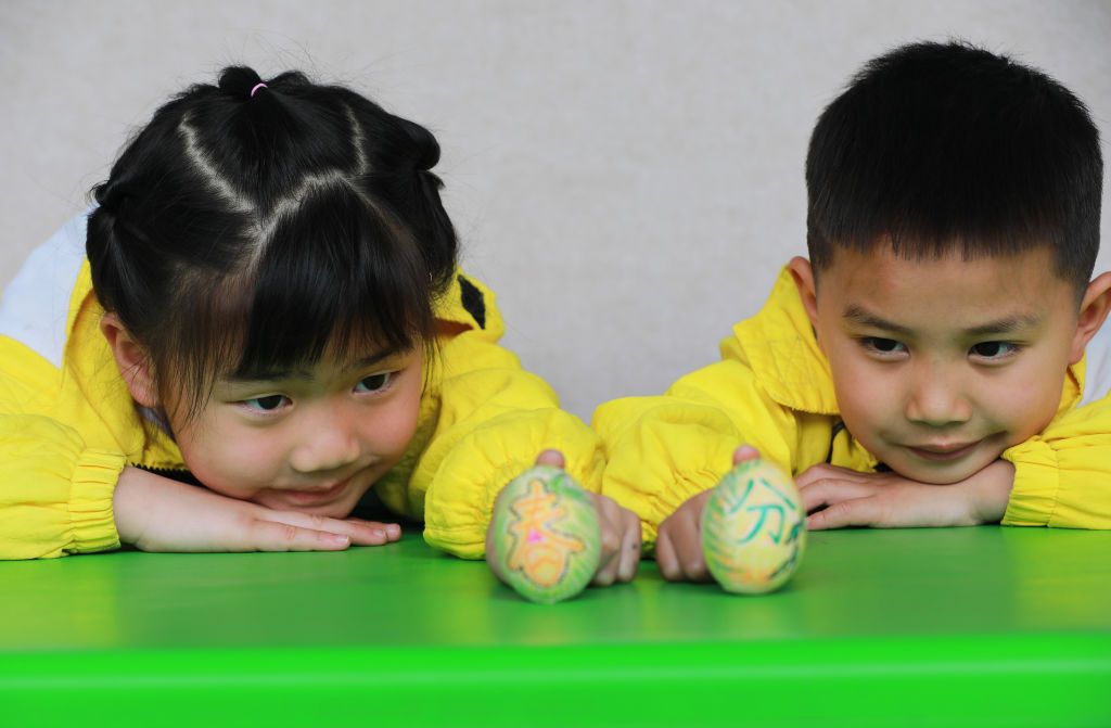 CONGJIANG, CHINA - MARCH 19: Children participate in the game of 'egg balancing' during the Spring Equinox at a kindergarten on March 19, 2021 in Congjiang County, Guizhou Province of China. (Photo by Luo Jinglai/VCG via Getty Images)