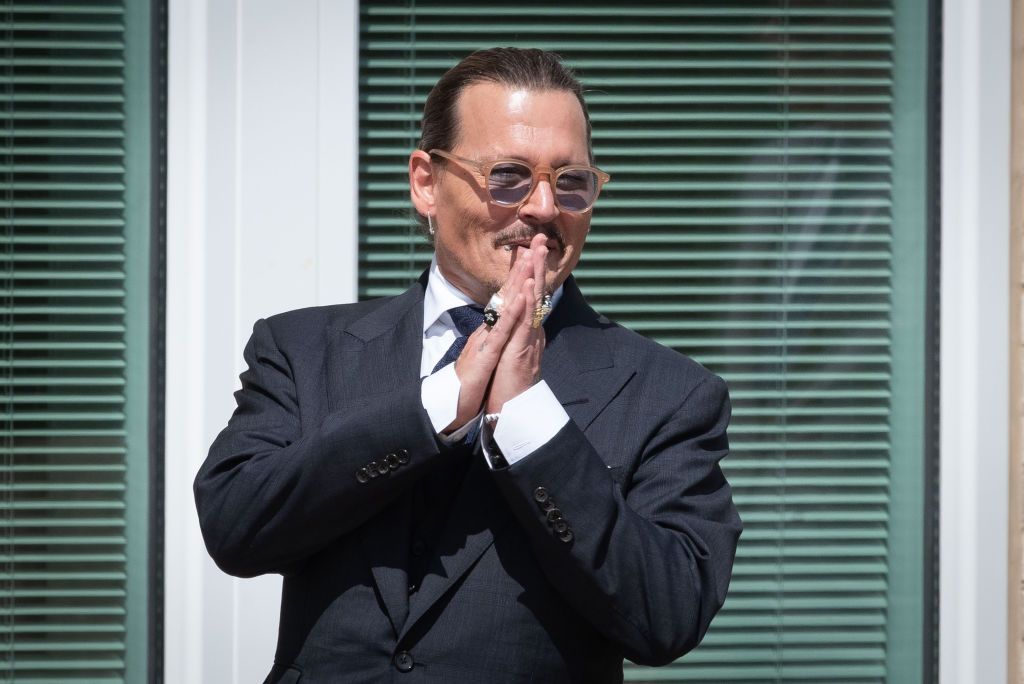 FAIRFAX, VA - MAY 17: (NY & NJ NEWSPAPERS OUT) Johnny Depp gestures to fans during a break outside court during the Johnny Depp and Amber Heard civil trial at Fairfax County Circuit Court on May 17, 2022 in Fairfax, Virginia. Depp is seeking $50 million in alleged damages to his career over an op-ed Heard wrote in the Washington Post in 2018. (Photo by Cliff Owen/Consolidated News Pictures/Getty Images)