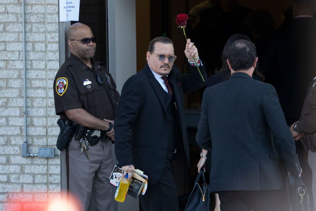 FAIRFAX, VA - MAY 18: (NY & NJ NEWSPAPERS OUT) Actor Johnny Depp holds a red rose as he arrives outside court during the Johnny Depp and Amber Heard civil trial at Fairfax County Circuit Court on MAY 18, 2022 in Fairfax, Virginia. Depp is seeking $50 million in alleged damages to his career over an op-ed Heard wrote in the Washington Post in 2018.(Photo by Chris Kleponis/Consolidated News Pictures/Getty Images)