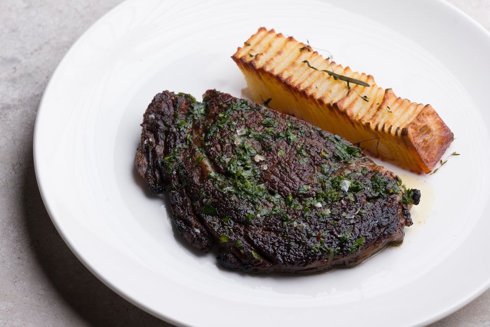 Open-fire roasted premium aged beef with domino potatoes