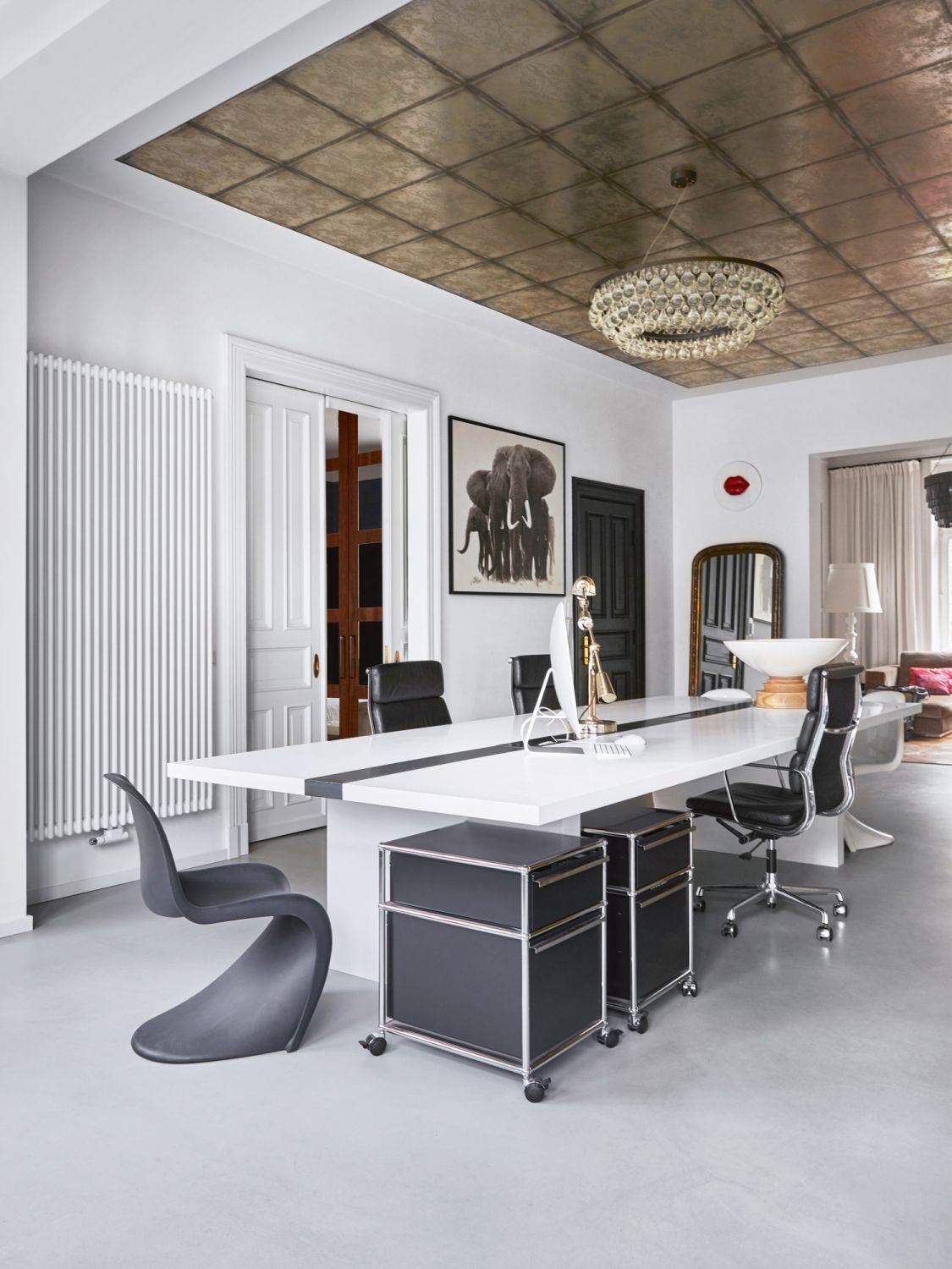 Applied to the ceiling, the Cole & Son wallpaper features an antique-like finish that adds character to the home office. The space also features a photographic print of elephants by Horst Klemm from Lumas Gallery
