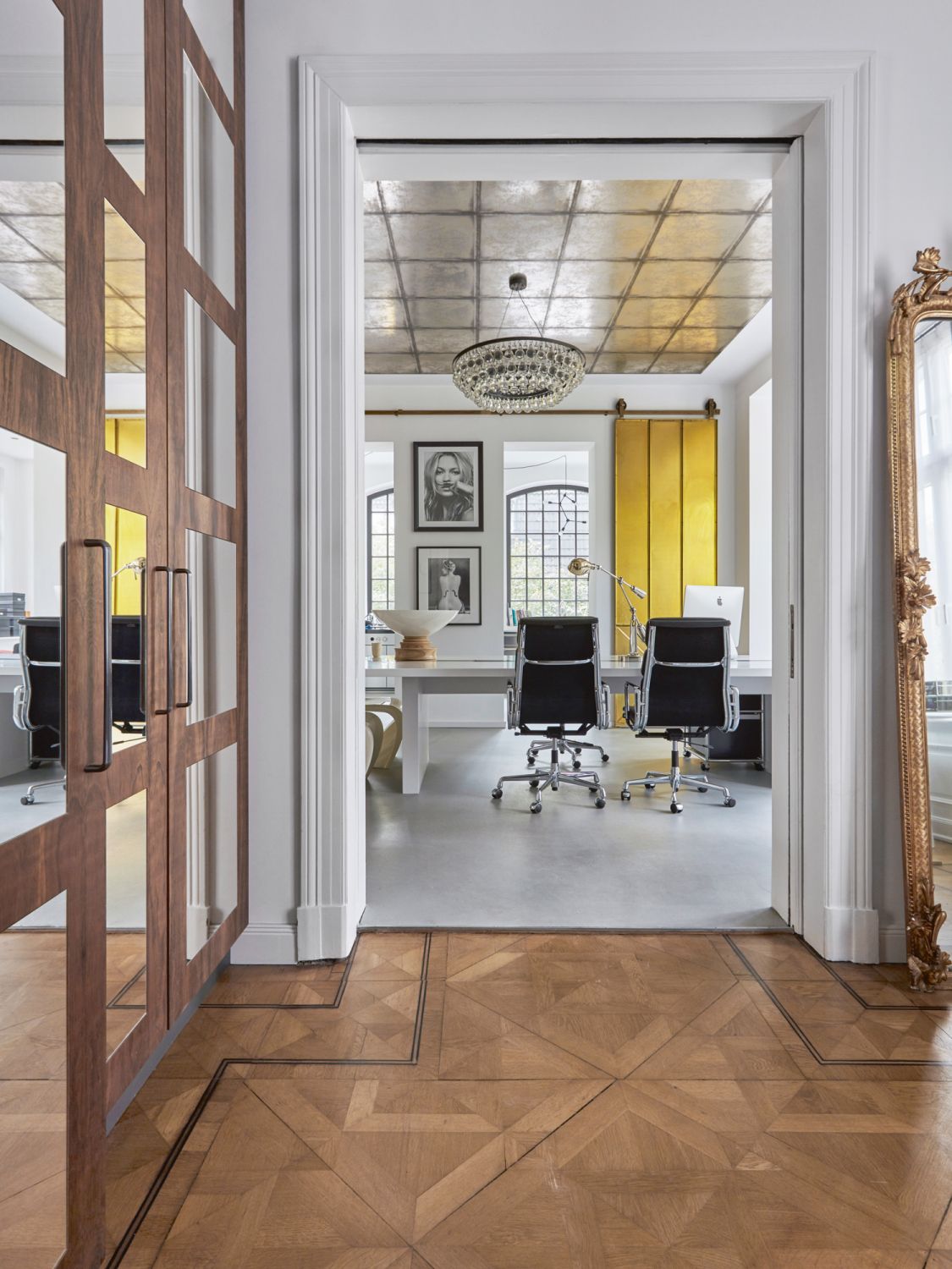 n antique gold mirror bought at an auction is set up casually by the entrance to the study
