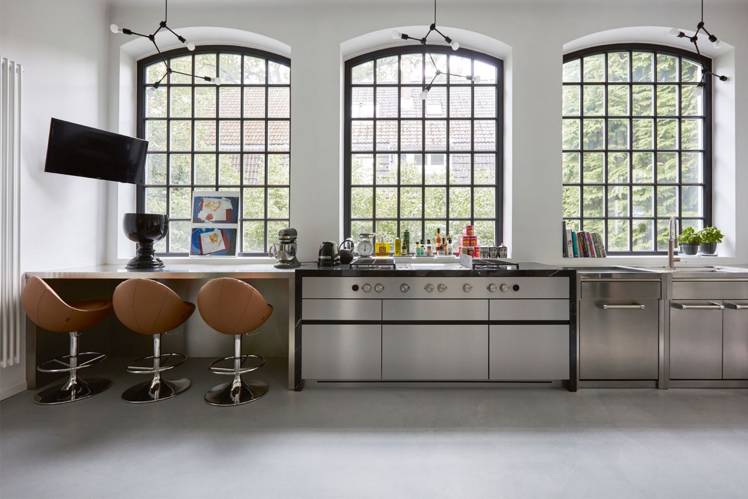 The culinary space features Italian cabinets sold by Little Chelsea, chairs from Johanson, and ceiling lamps from Denmark