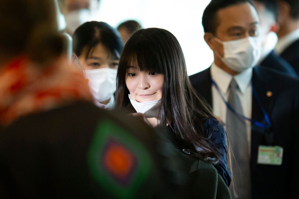TOKYO, JAPAN - NOVEMBER 14: Mako Komuro removes her face mask for face recognition upon departure at Haneda Airport on November 14, 2021 in Tokyo, Japan. (Photo by Yuichi Yamazaki/Getty Images)