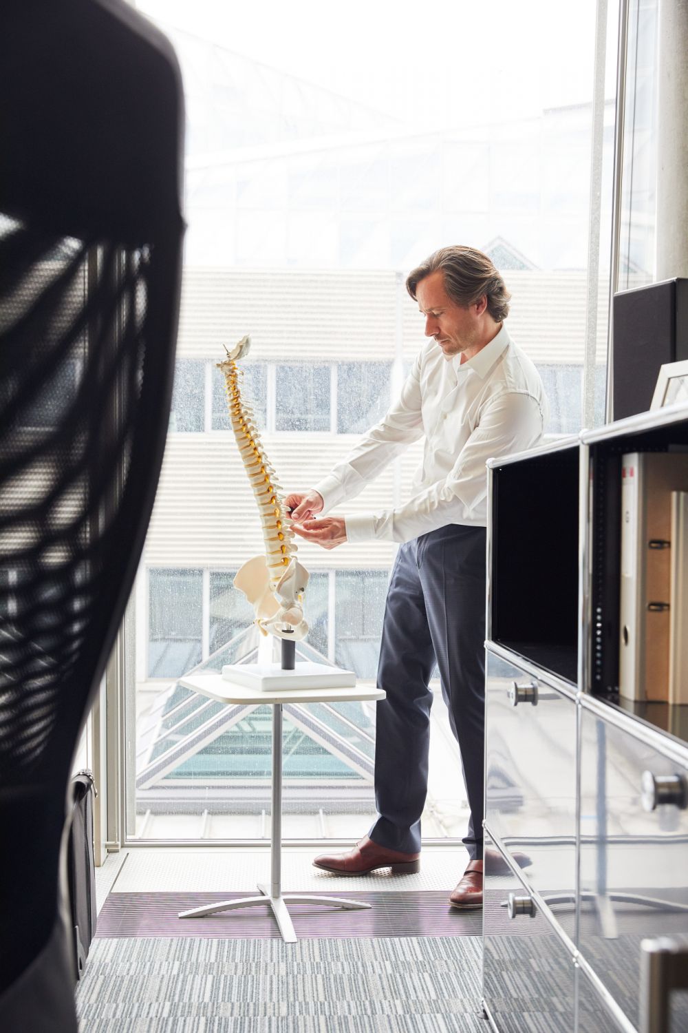 GrÃ©goire Courtine with a skeleton of a human spine in his office at Campus Biotech, Geneva.