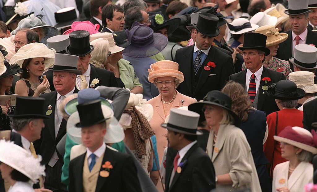 ASCOT, UNITED KINGDOM - JUNE 17: The Queen Walking Through The Crowd At Ascot Races. Followed By Her Royalty Protection Police Bodyguard David Robinson In Black Top Hat On Far Right (Photo by Tim Graham Photo Library via Getty Images)