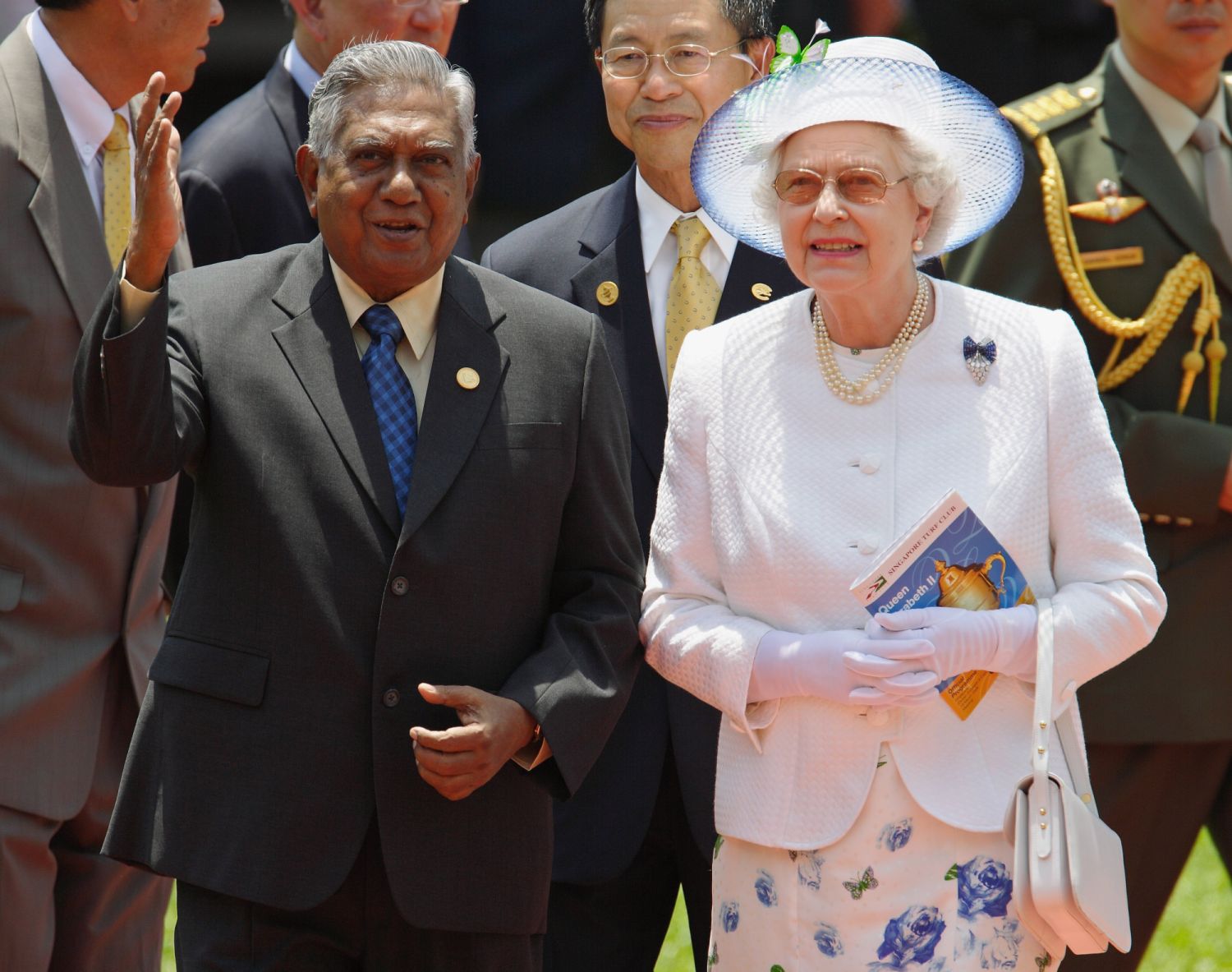 Queen Elizabeth II walks with Singapore President S.R. Nathan while touring the Singapore Turf Club on 18 March, 2006 in Singapore. Behind them at center is Singapore Turf Club chairman Koh Yong Guan. (Photo: Getty Images)