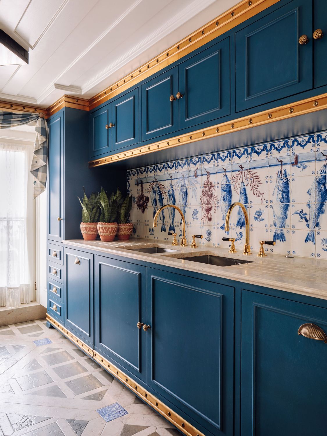 Dark blue cabinetry add a bold touch to the kitchen