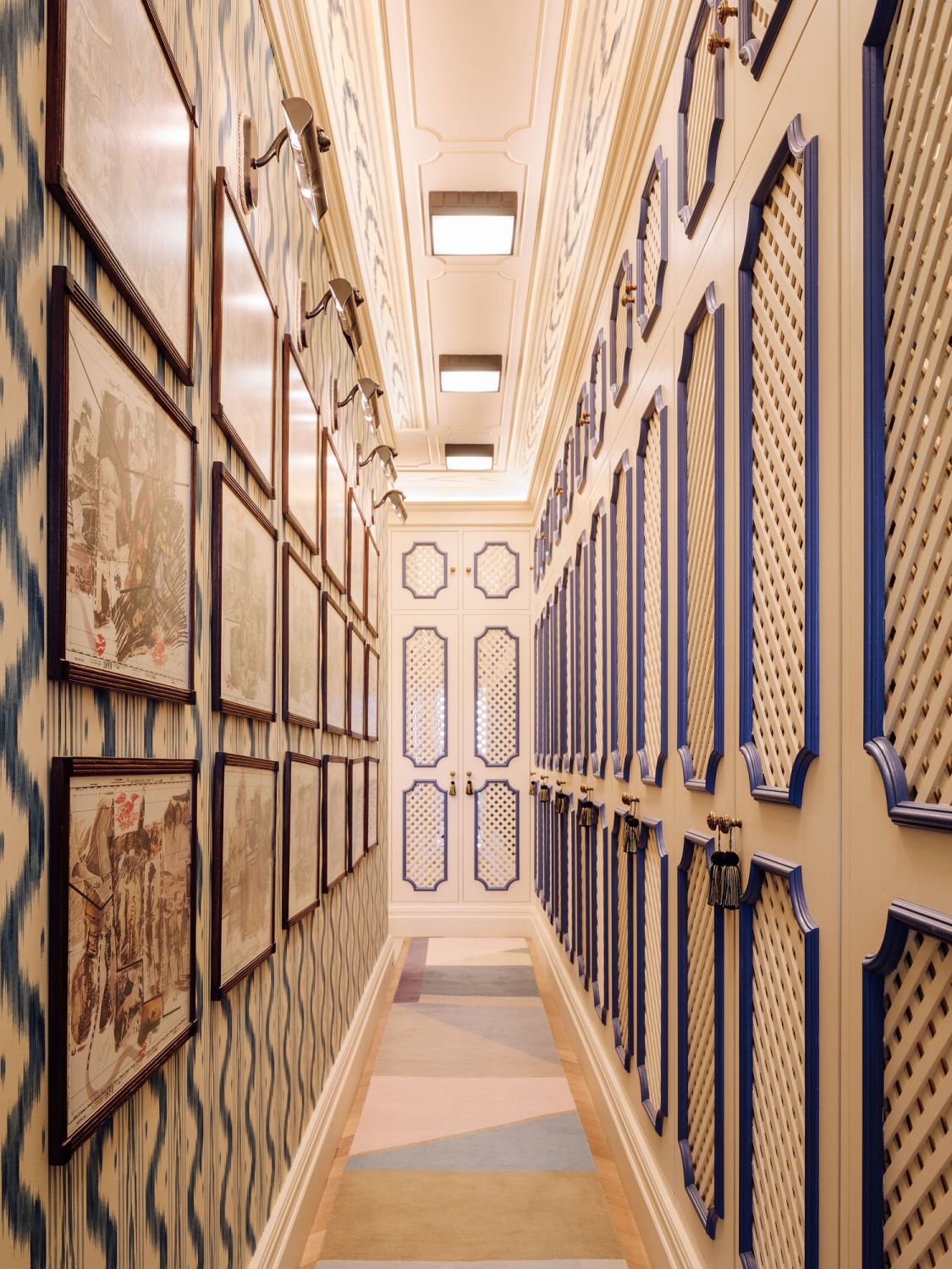 A hallway in the mansion with one wall entirely lined with framed artworks
