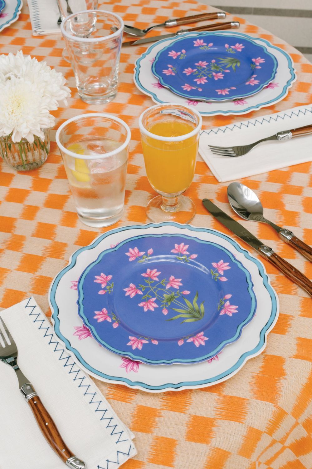 lates from Perla x Flora Magica, napkins from Malaika Linens, cutlery from Laguiole, water goblets from Daylesford Organic, and tablecloth made from Indian ikat fabric complete the summer setting
