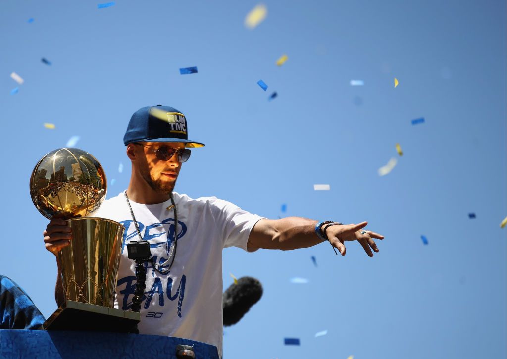 OAKLAND, CA - JUNE 12: Stephen Curry #30 of the Golden State Warriors holds the championship trophy during the Golden State Warriors Victory Parade on June 12, 2018 in Oakland, California. The Golden State Warriors beat the Cleveland Cavaliers 4-0 to win the 2018 NBA Finals. NOTE TO USER: User expressly acknowledges and agrees that, by downloading and or using this photograph, User is consenting to the terms and conditions of the Getty Images License Agreement. (Photo by Ezra Shaw/Getty Images)