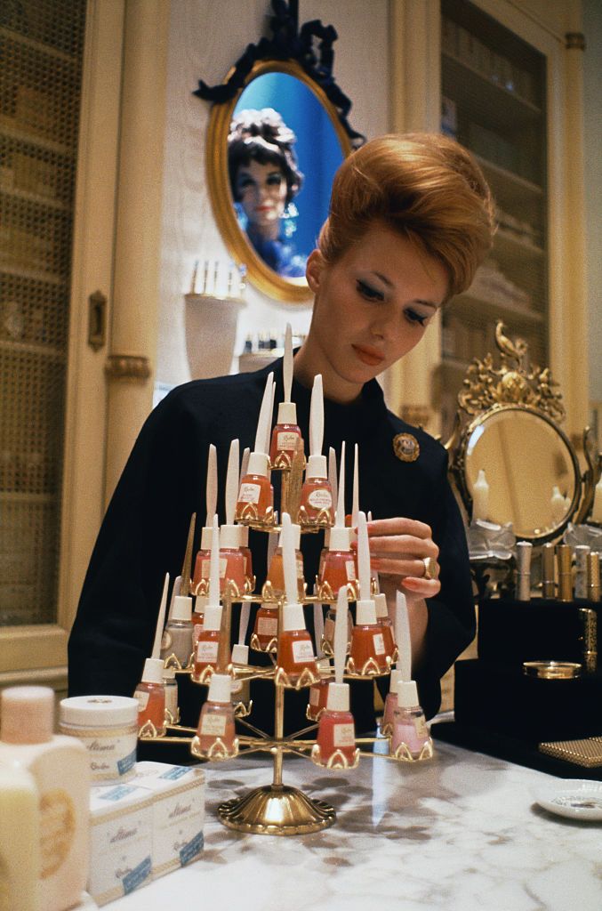 (Original Caption) Manhattan, New York, New York: House of Revlon, beauty salon. Model stands behind table of Revlon polish.
