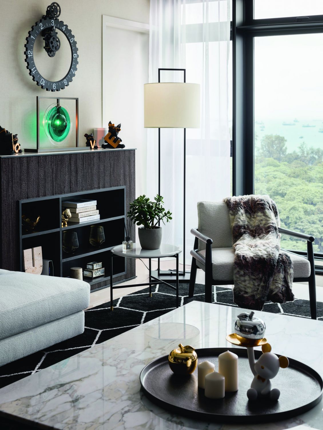 The angular black detailing of the lamp and furnishings matches the linear form of the living area while complementing the home’s monochromatic colour scheme