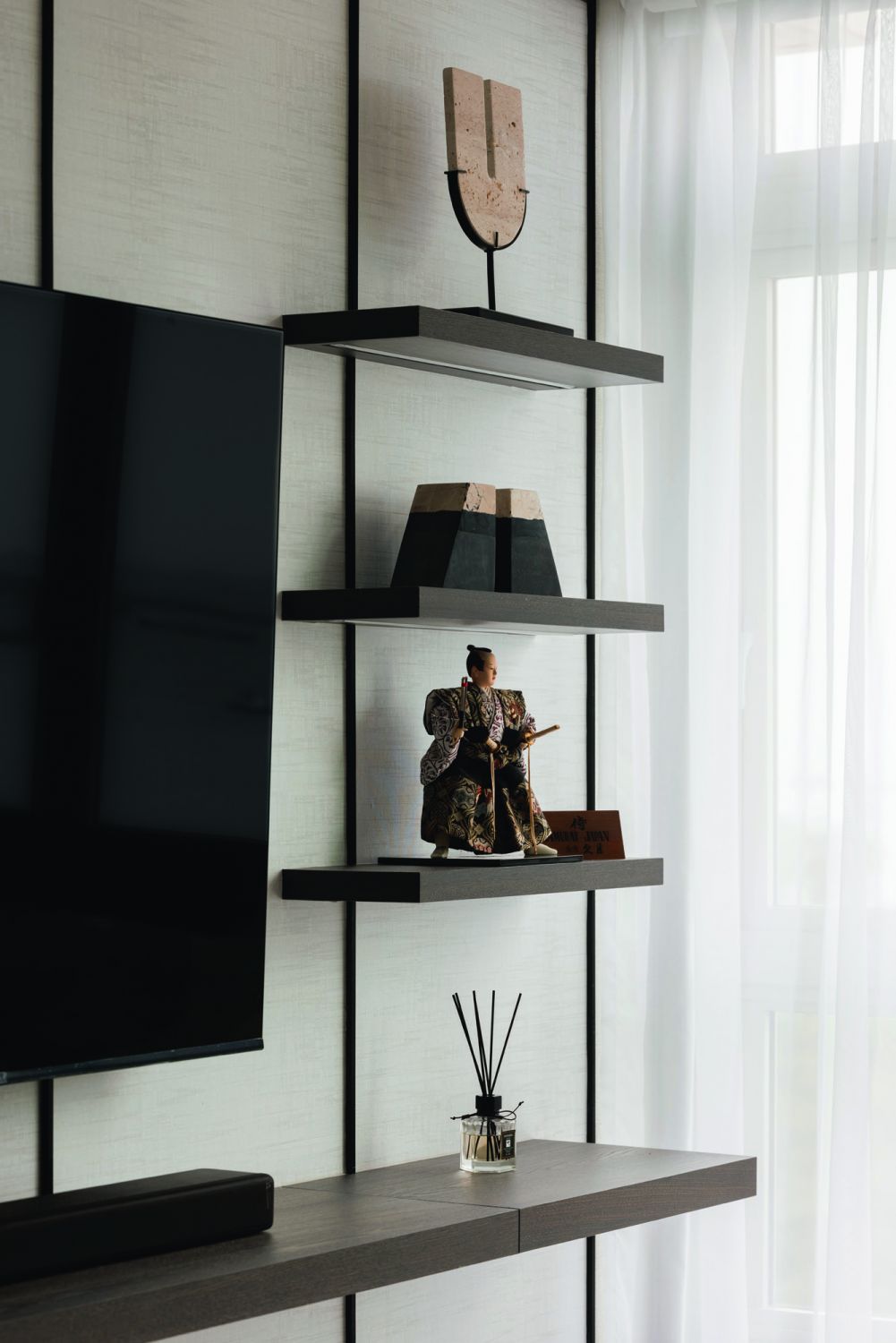The considered mix of decorative objects adds a modern Asian flair to these display shelves in the living room