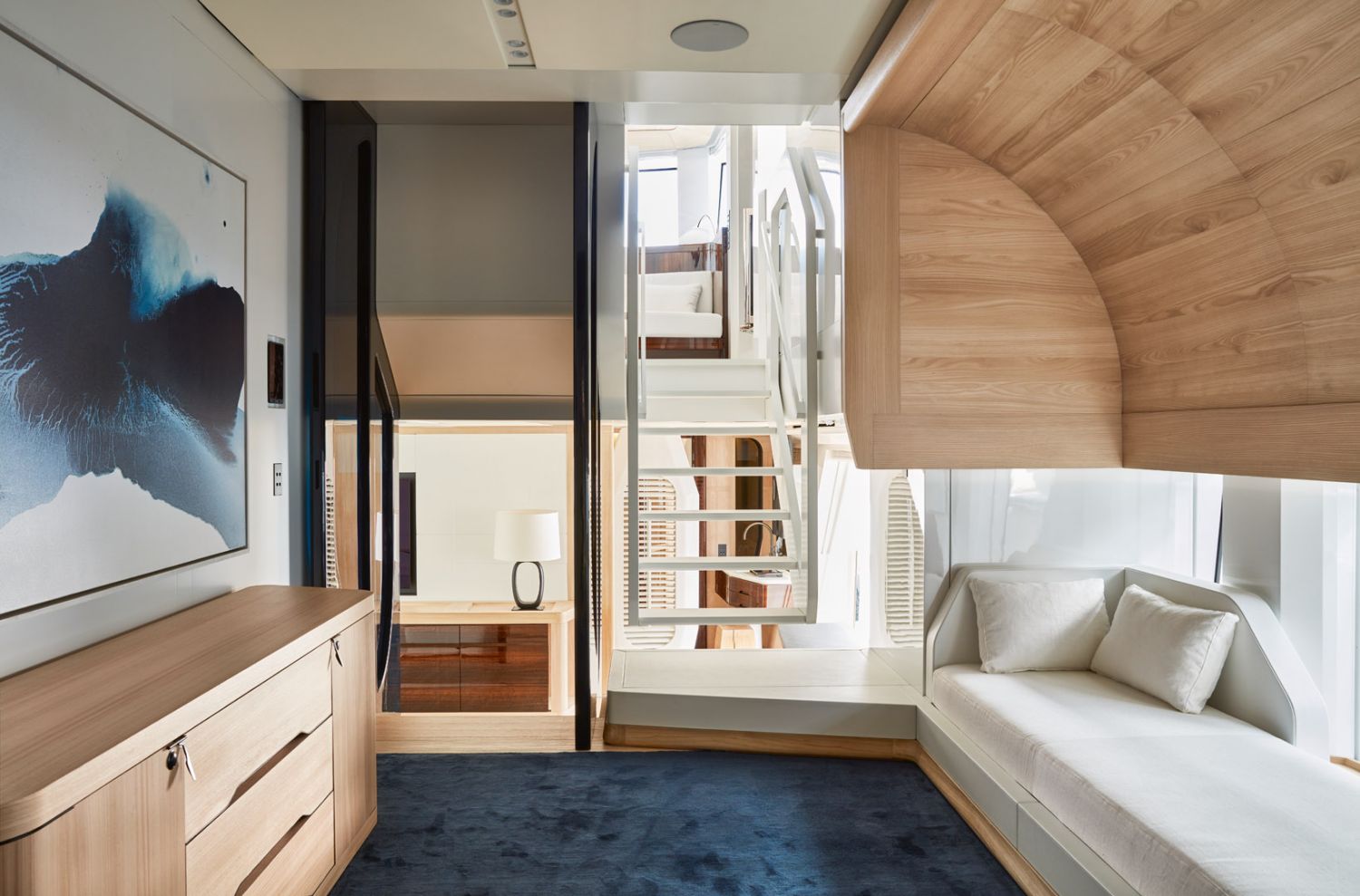 The blue tones on the carpeting, artwork and accent wall contribute to the tranquil ambience of the off-white interior scheme in the owner’s cabin