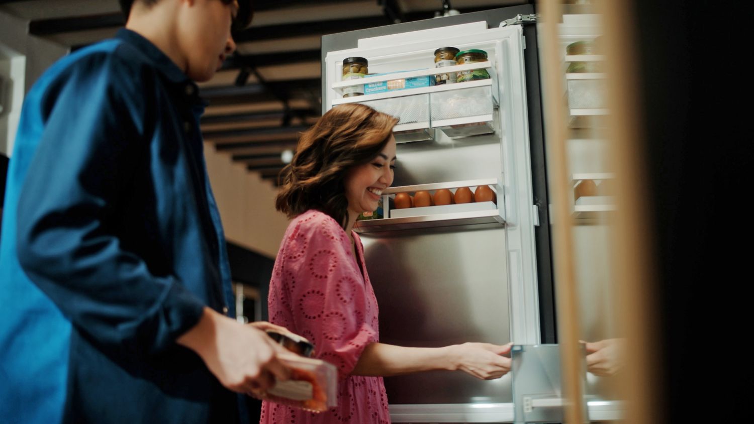 Wee and Chen packing away groceries into the Liebherr fully integrated ICBNh 5173 refrigerator