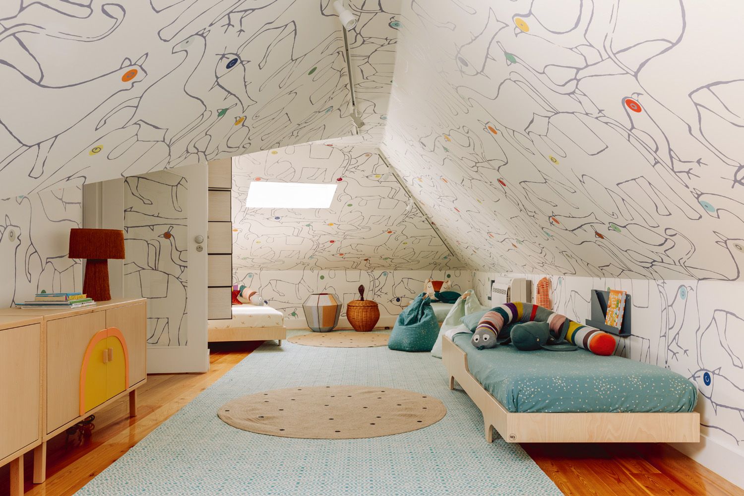 The attic features walls and a ceiling decked in a playful wallpaper featuring animal motifs