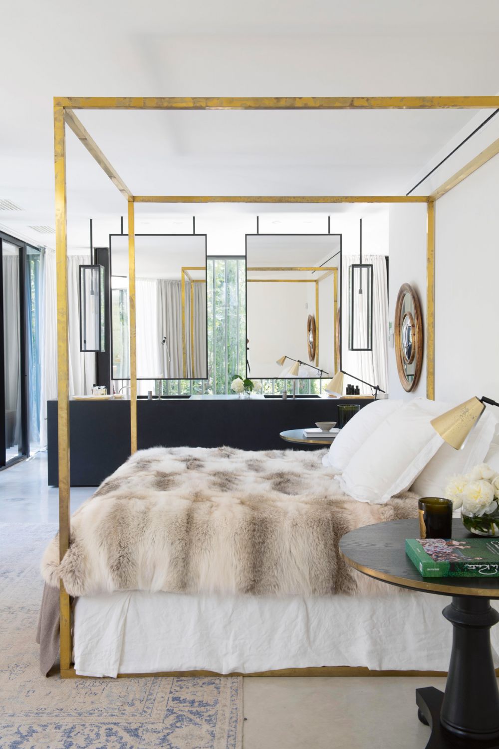 The angular elements in the open-plan master suite are softened by the round forms of the bedside tables and the cosy fur throw on the bed