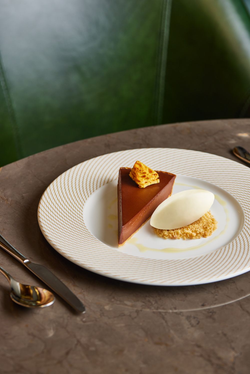 The 64% Manjari Chocolate Tart is served with a honeycomb and buttermilk sorbet, making it a perfect ending to any meal.
