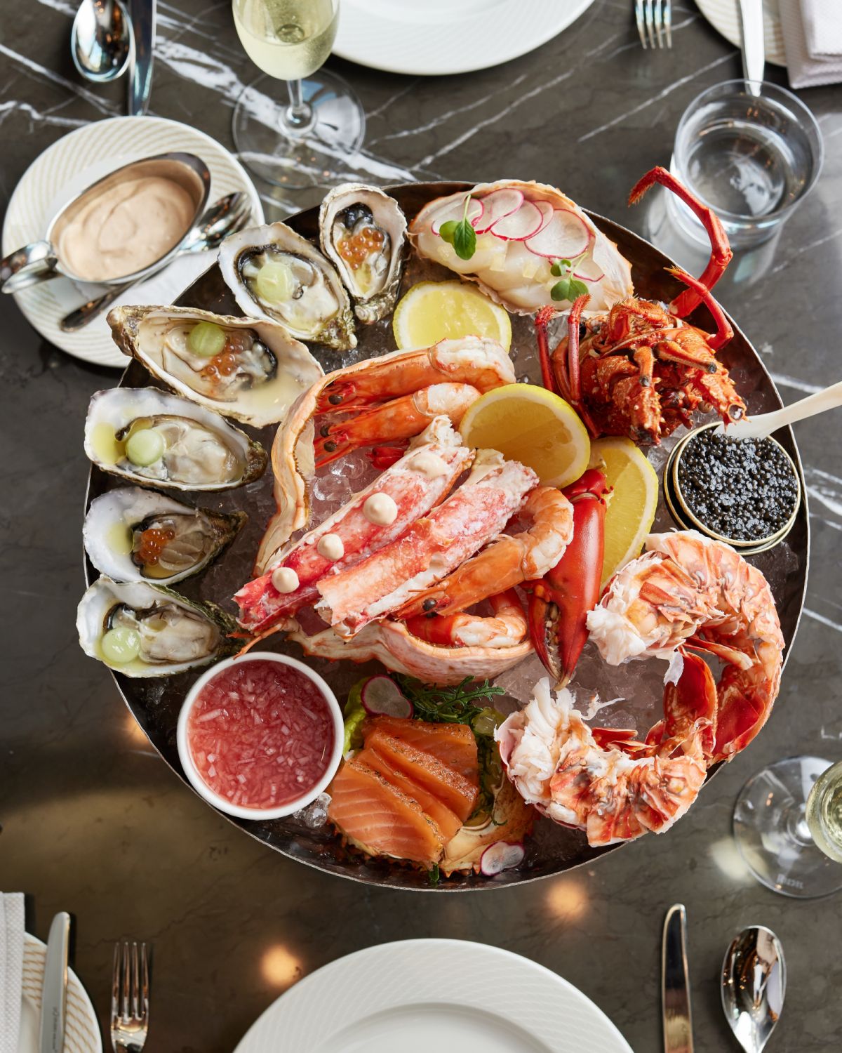 aThe seafood tower s a glimpse at the best the oceans have to offer with fresh oysters, Boston lobster, scallop ceviche, king crab legs, prawns, and pieces of citrus-cured salmon.