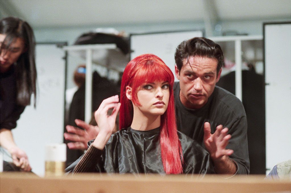 Fashion model Linda Evangelista dons a red wig for a fashion show at the Musee du Louvre in Paris, France. A celebrity hairstylist Oribe Canales helps her prepare for the show. (Photo by David Turnley/Corbis/VCG via Getty Images)