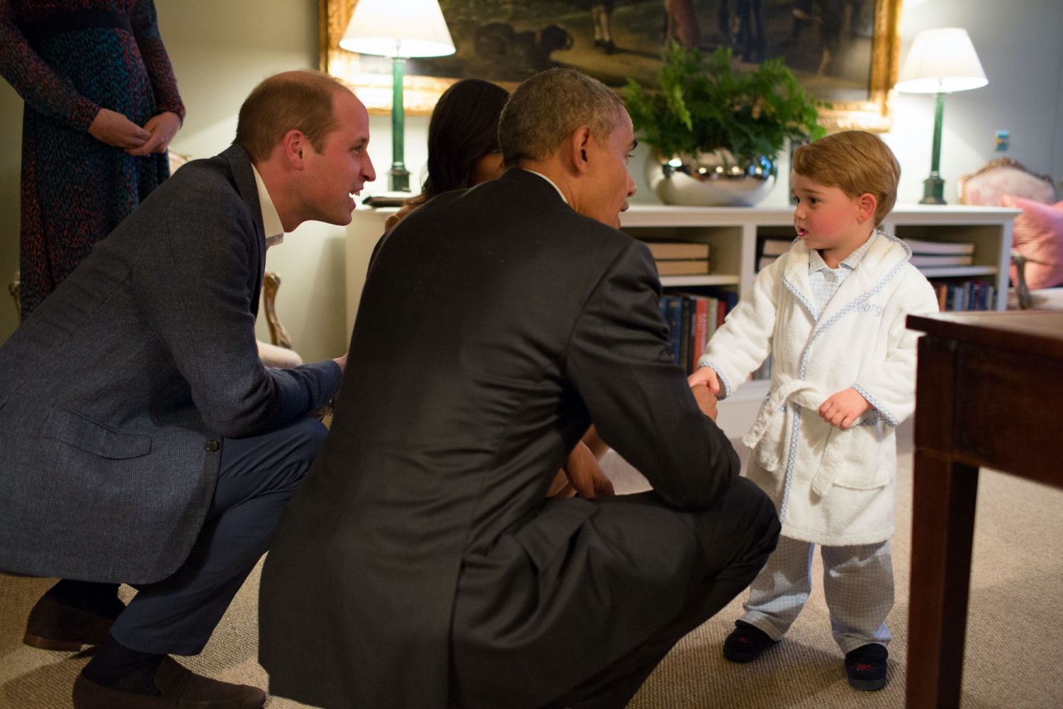 LONDON, ENGLAND - APRIL 22:   In this handout provided by The White House, President Barack Obama, Prince William, Duke of Cambridge and First Lady Michelle Obama talks with Prince George at Kensington Palace on April 22, 2016 in London, England. The President and his wife are currently on a brief visit to the UK where they attended lunch with HM Queen Elizabeth II at Windsor Castle and later dinner with Prince William and his wife Catherine, Duchess of Cambridge at Kensington Palace. Mr Obama visited 10 Do