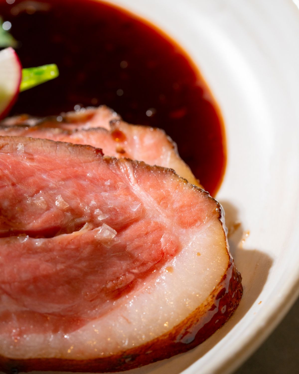 A close up shot of LI Restaurant's Roselle Pork Shoulder, which highlights its juiciness