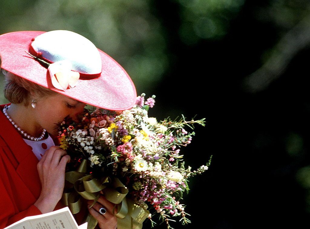 MELBOURNE, AUSTRALIA - NOVEMBER 03: Princess Diana Smelling The Flowers In A Bouquet She Has Been Given During A Visit To The Royal Botanical Gardens In Melbourne, Australia. (Photo by Tim Graham Photo Library via Getty Images)