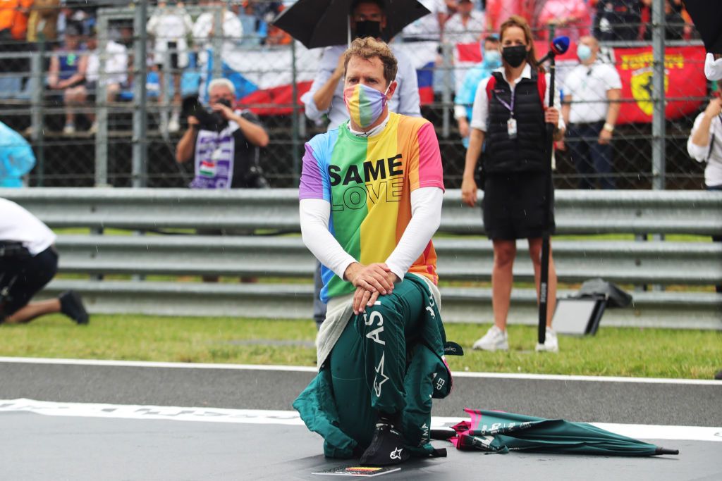BUDAPEST, HUNGARY - AUGUST 01: Sebastian Vettel of Germany and Aston Martin F1 Team takes a knee on the grid as part of the We Race As One gesture before the F1 Grand Prix of Hungary at Hungaroring on August 01, 2021 in Budapest, Hungary. (Photo by Florion Goga - Pool/Getty Images)