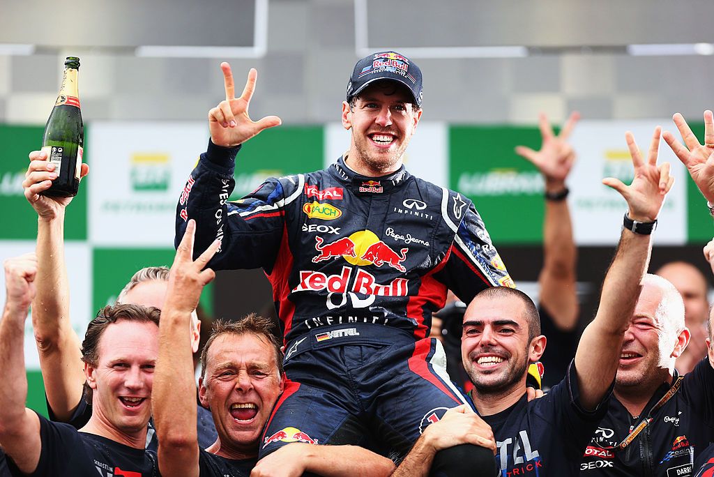 SAO PAULO, BRAZIL - NOVEMBER 25: Sebastian Vettel of Germany and Red Bull Racing celebrates with team mates on the podium as he finishes in sixth position and clinches the drivers world championship during the Brazilian Formula One Grand Prix at the Autodromo Jose Carlos Pace on November 25, 2012 in Sao Paulo, Brazil. (Photo by Paul Gilham/Getty Images)